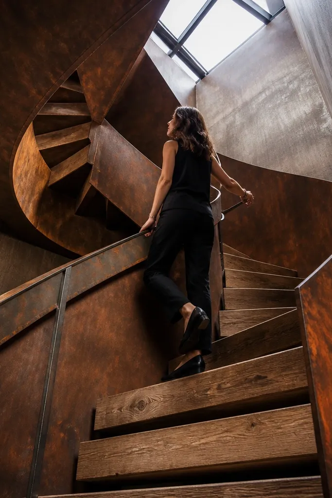 Rusty corten-style spiral staircase with wood steps