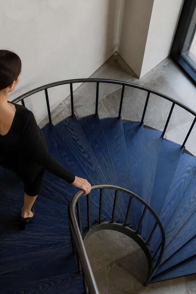 Deep blue tinted spiral staircase treads with black rail