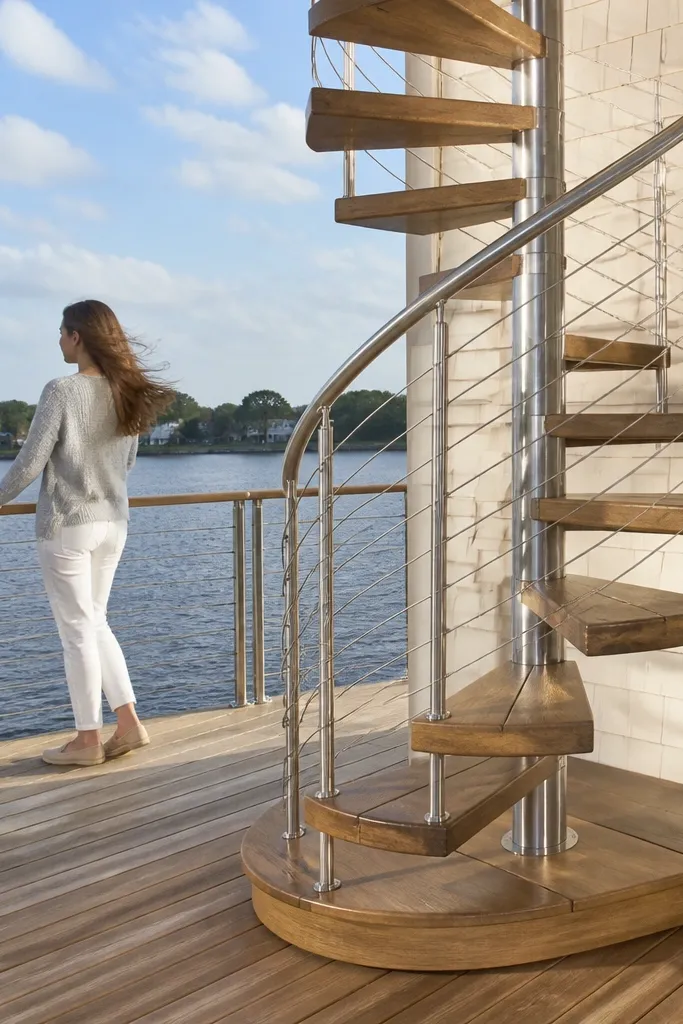 Outdoor spiral staircase with pressure-treated treads and stainless handrail
