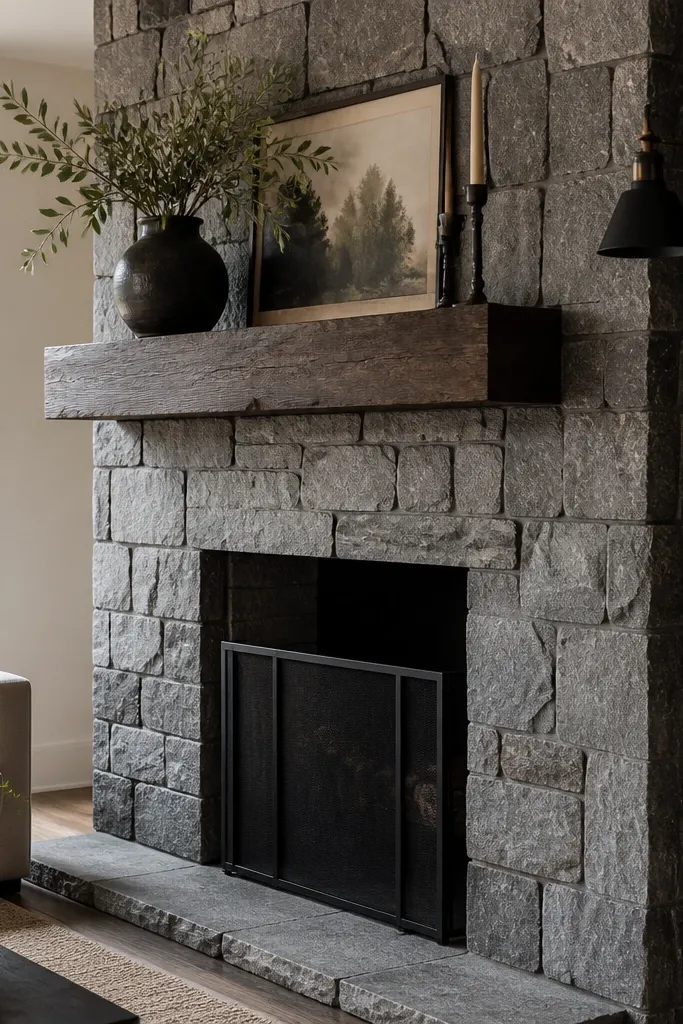 Basalt gray irregular stone fireplace with a dark walnut mantel and black accents.