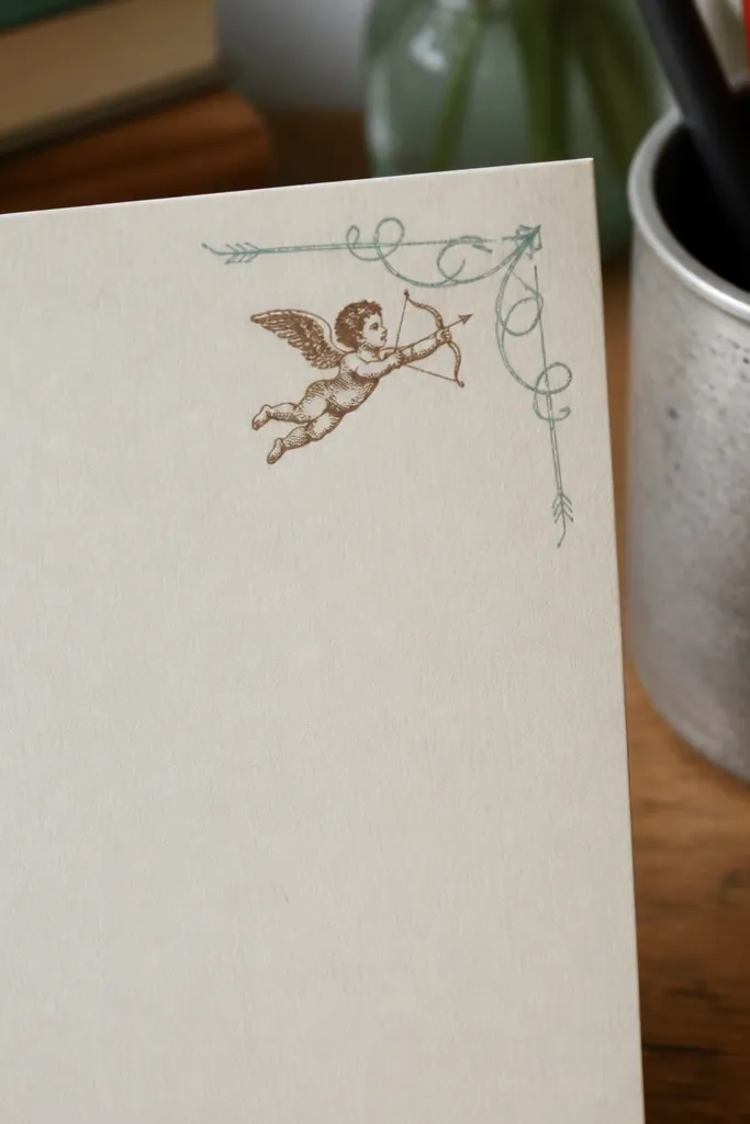 A small worn arrow with a cupid motif, designed for the top corner of a note.