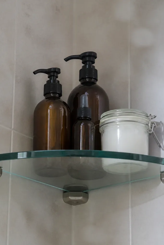 Small glass corner shelves with matte metal brackets and clean lines.