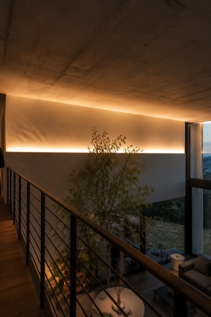 Warm LED line hidden in a ceiling cove along a double-height balcony edge