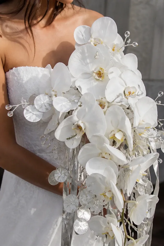 White orchid-like blooms with silver money strips and clear accents