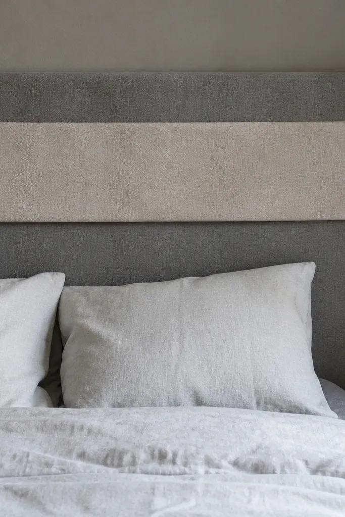 Grey headboard with a pale linen runner along the top edge