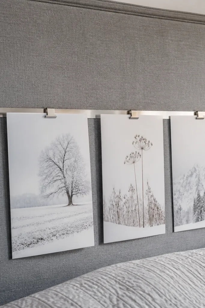 Grey headboard with a row of small framed prints above it