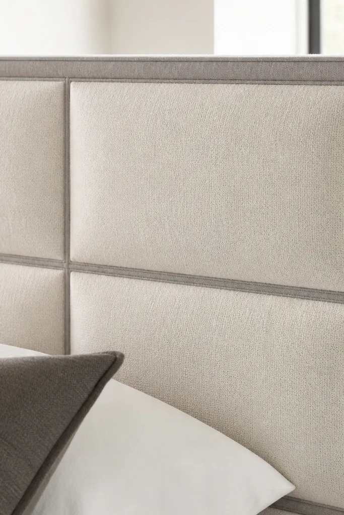 Grey headboard with fabric-wrapped panels outlined in dark trim