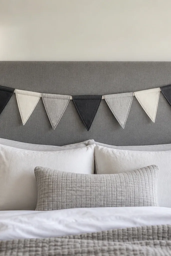 Grey headboard with a short row of muted grey fabric pennants above it